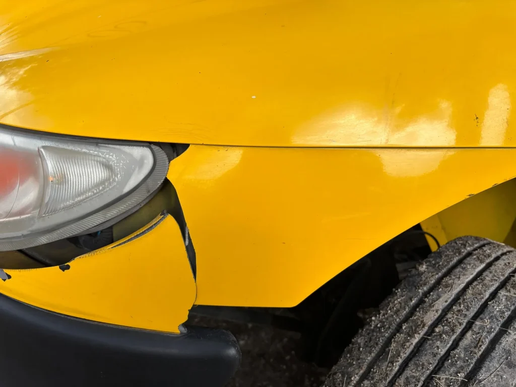 Accident damage to a front bumper and headlight