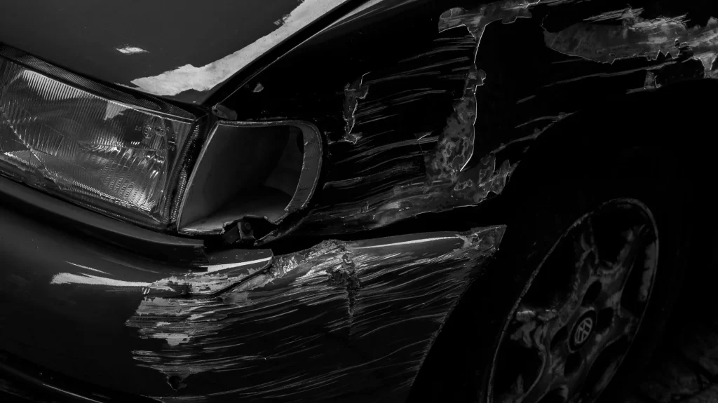 Deep scratches and gouges along a car's front wing and bumper